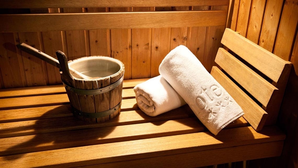 un sauna en bois avec des serviettes et un seau en bois