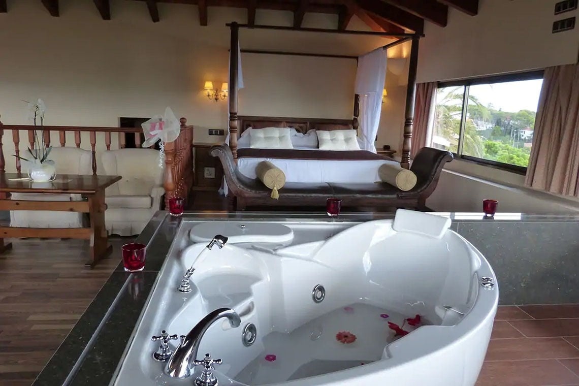 una habitación con una cama con dosel y una jacuzzi