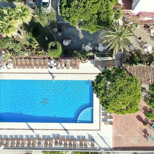 una vista aérea de una piscina rodeada de sillas y árboles