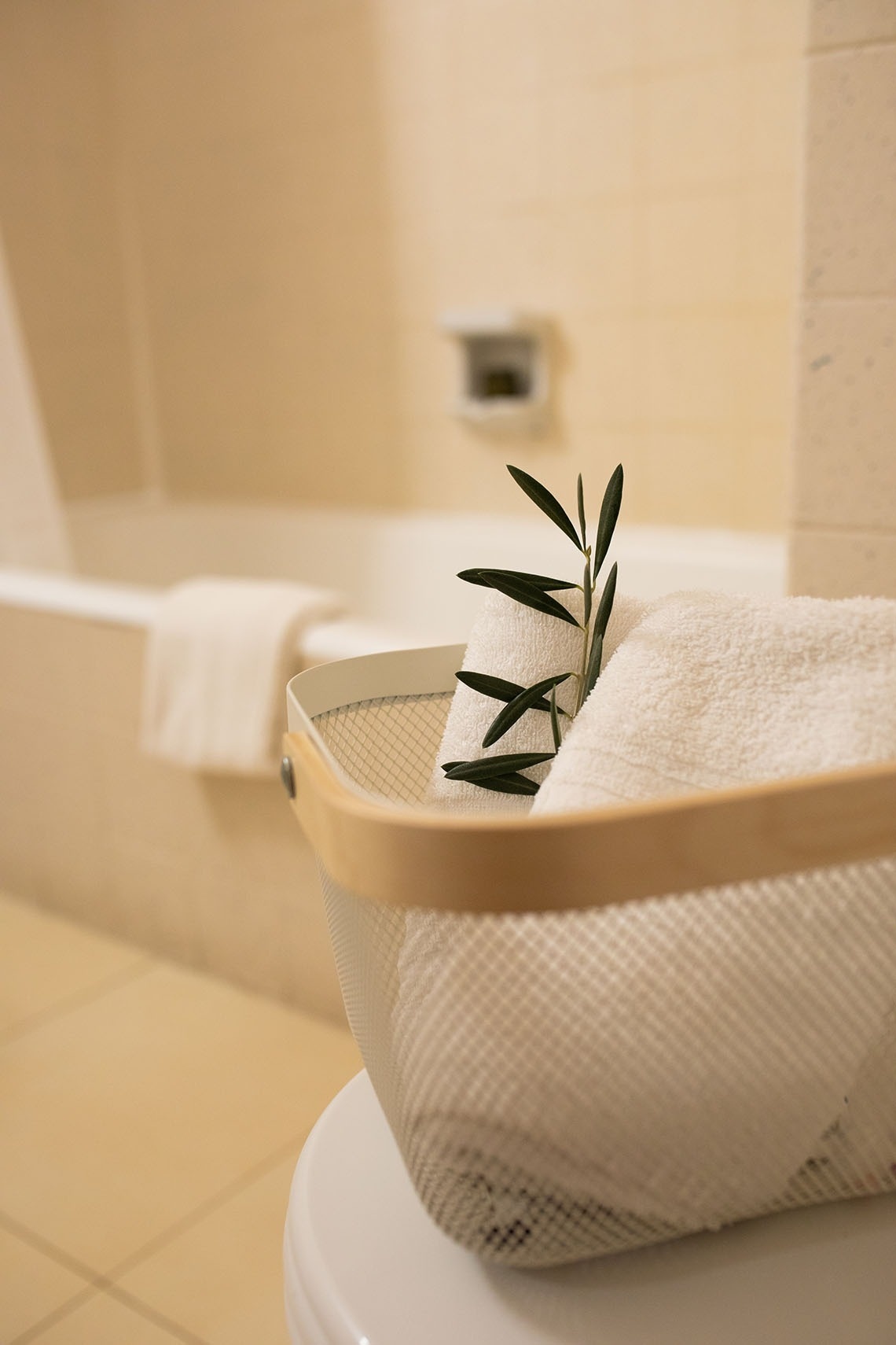 una cesta de lavandería con toallas y una planta encima