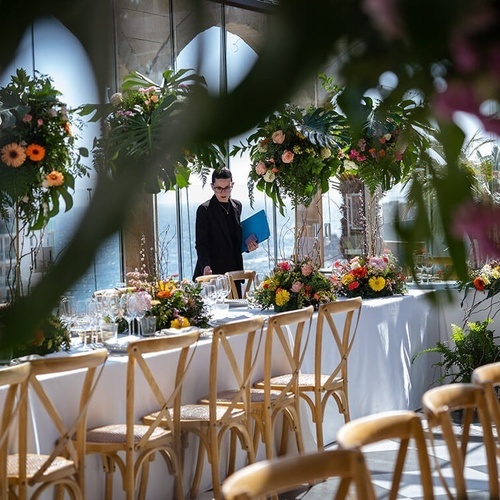 un hombre está parado frente a una mesa decorada con flores