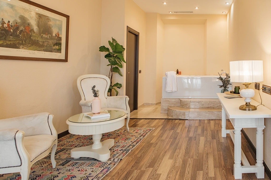 una habitación con una mesa y una silla junto a una bañera