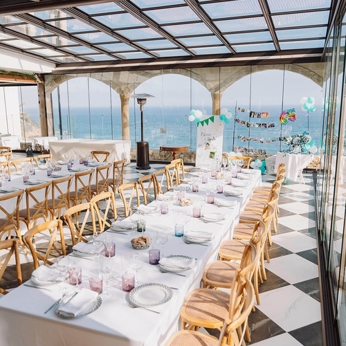 una habitación llena de mesas y sillas con un cartel en la pared que dice ' fiesta '