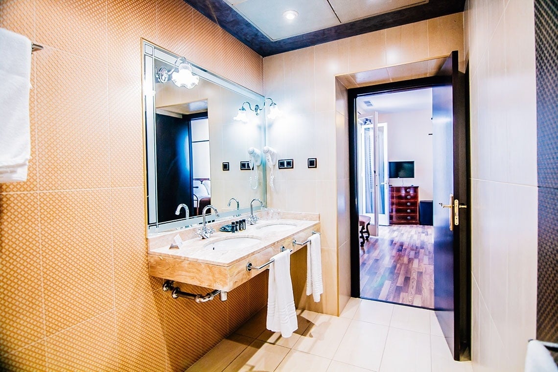 un baño con dos lavabos y un gran espejo