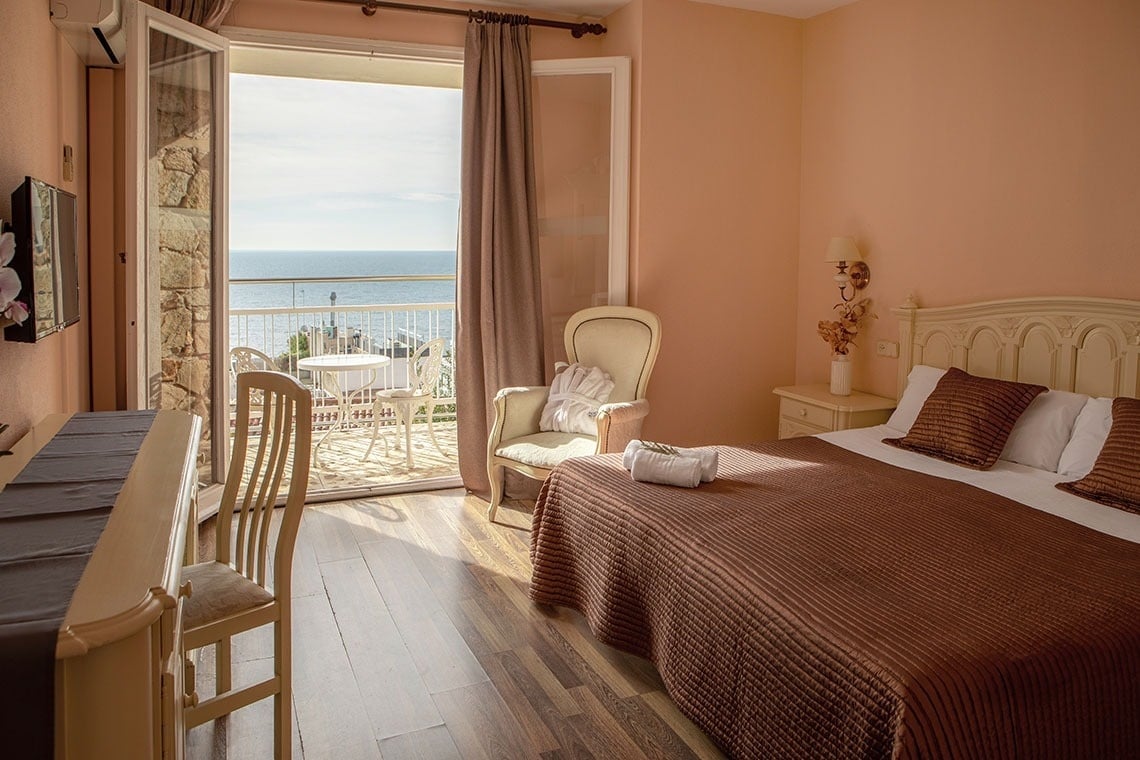 una habitación con una cama y una silla con vista al océano