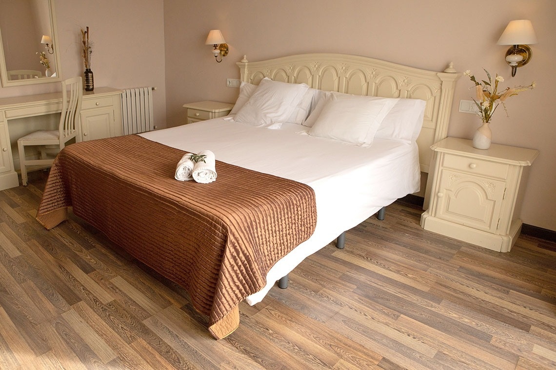 una habitación con una cama y dos mesitas de noche