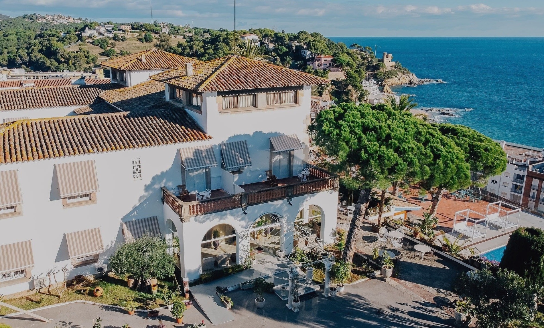 a large white building with a balcony overlooking the ocean