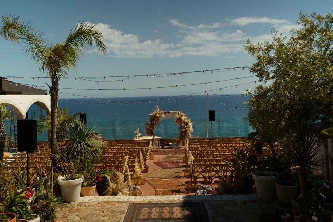 Wedding ceremony at Roger De Flor By Seleqtta overlooking the sea. Seating and altar.