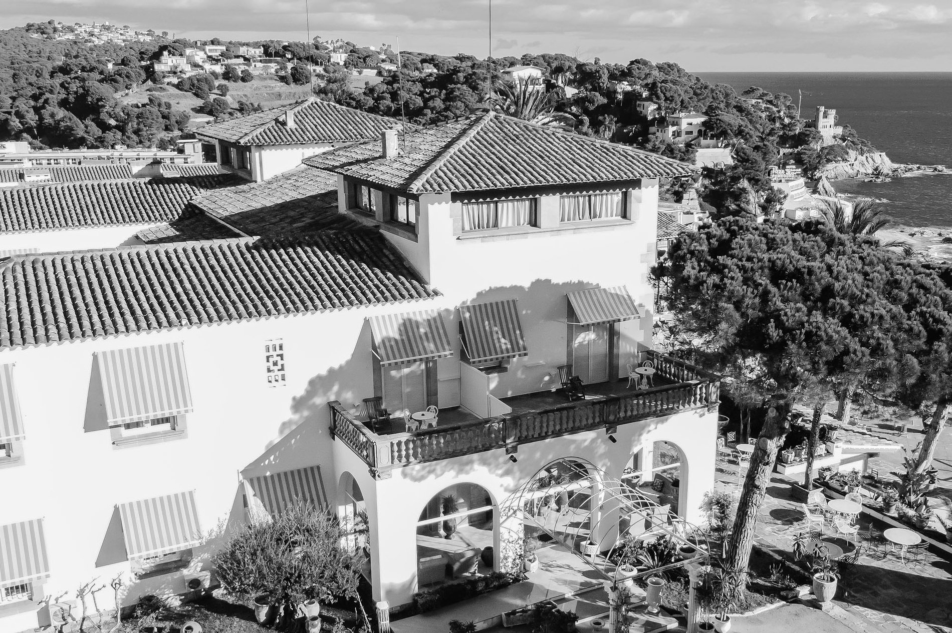 a black and white photo of a large white building with a balcony=s1900