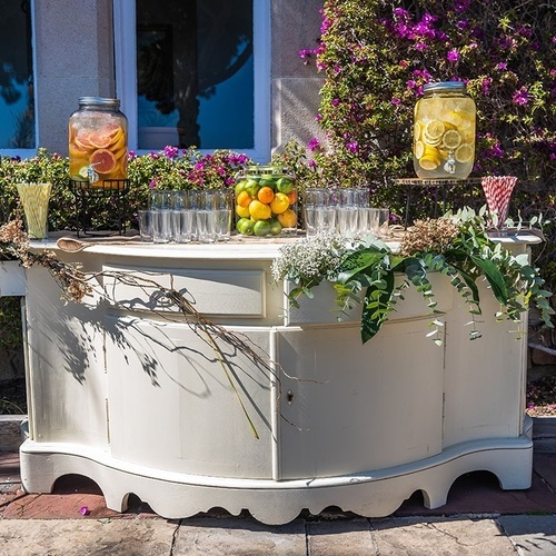 una mesa blanca con jarras de limonada y vasos