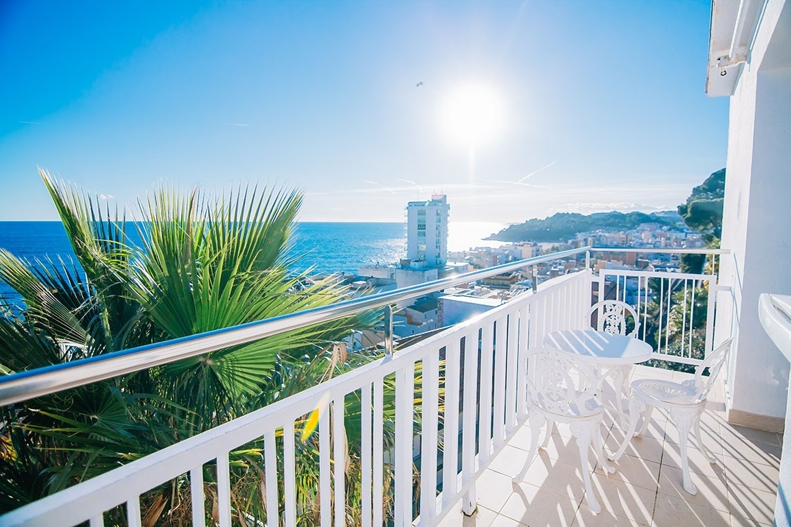 una mesa y sillas en un balcón con vistas al océano