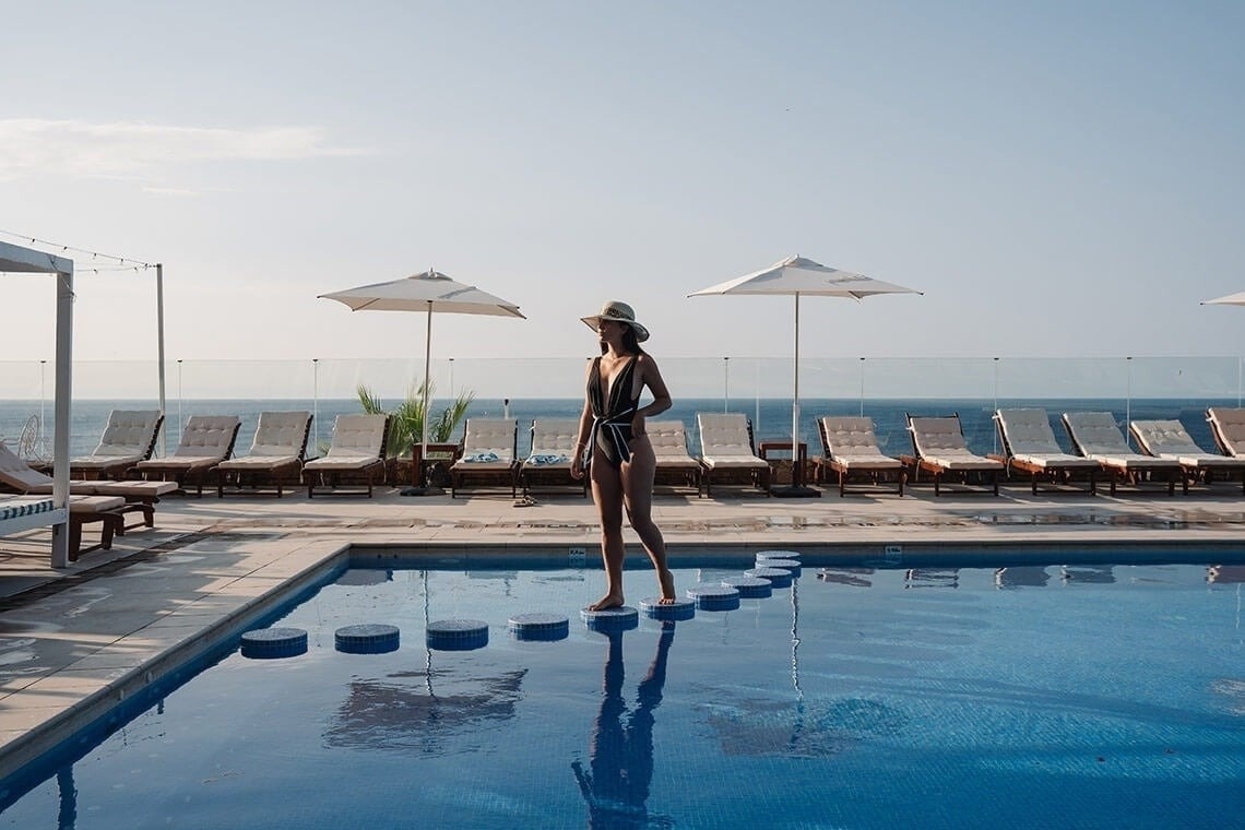 a bar with stools and bottles of liquor on shelves