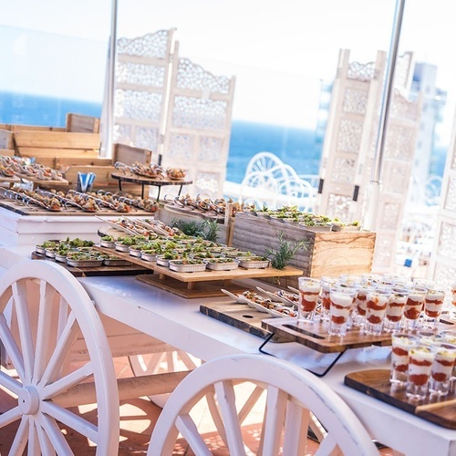 un carrito de madera lleno de platos y vasos de comida