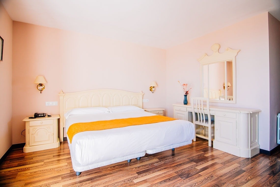 una habitación de hotel con una cama y un escritorio