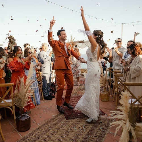 una novia y un novio celebran su matrimonio con confeti en el aire