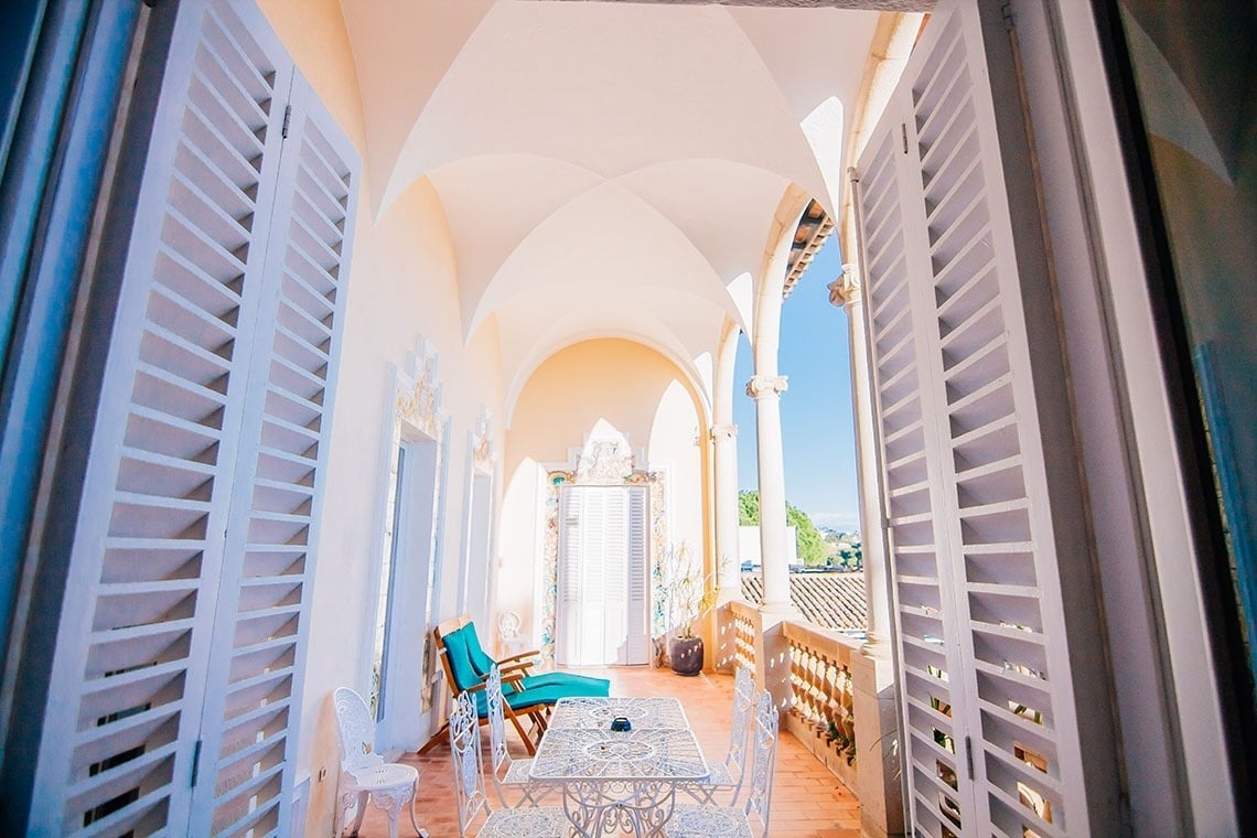 una mesa y sillas en un balcón con persianas blancas