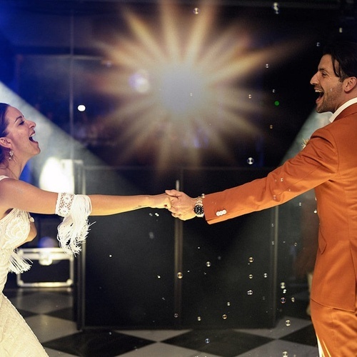 una novia y un novio bailan con burbujas en el fondo