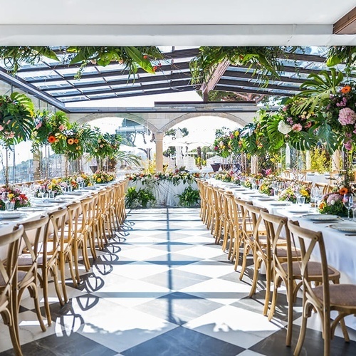 una larga mesa y sillas en una habitación decorada con flores