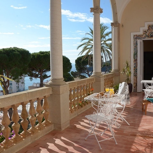 una mesa y sillas en un balcón con vistas al océano