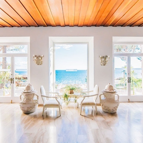 una habitación llena de muebles y ventanas con vistas al océano