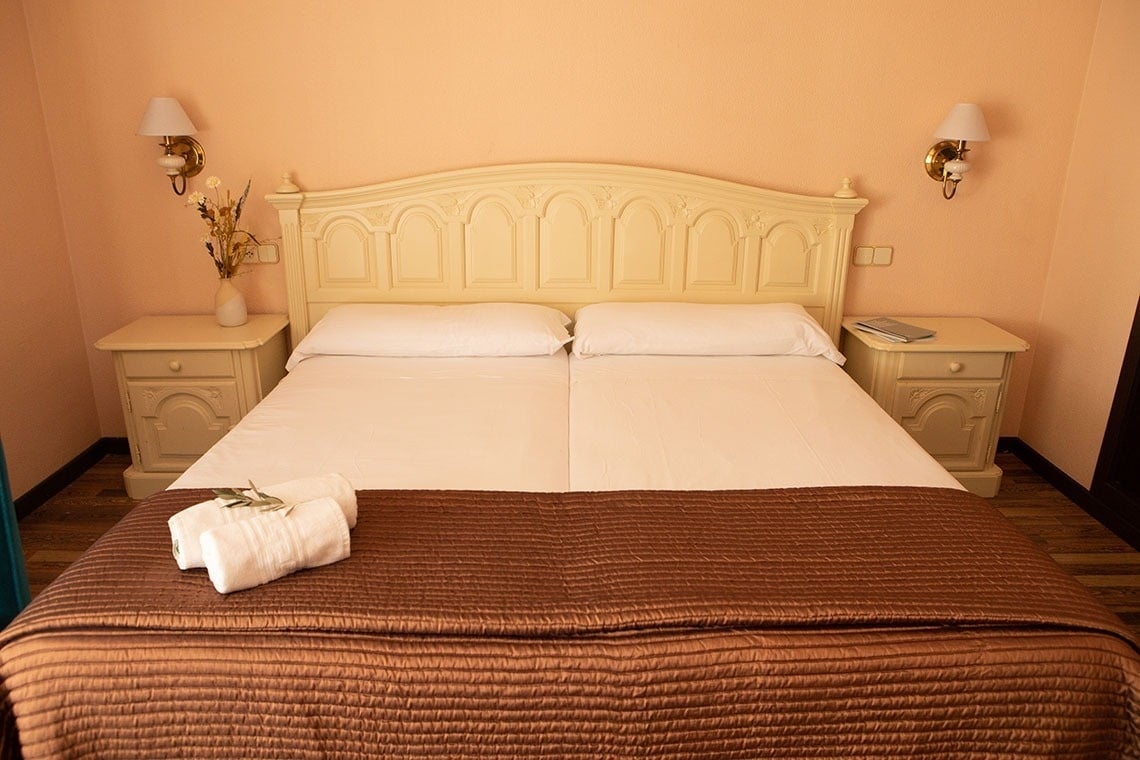 una habitación con una cama y dos mesitas de noche