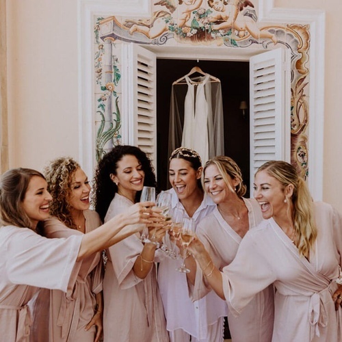 una novia y sus damas de honor brindan con champán