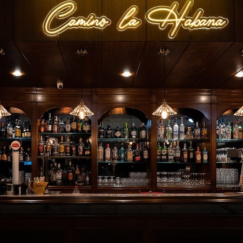 un bar con un letrero de neón que dice camino la habana