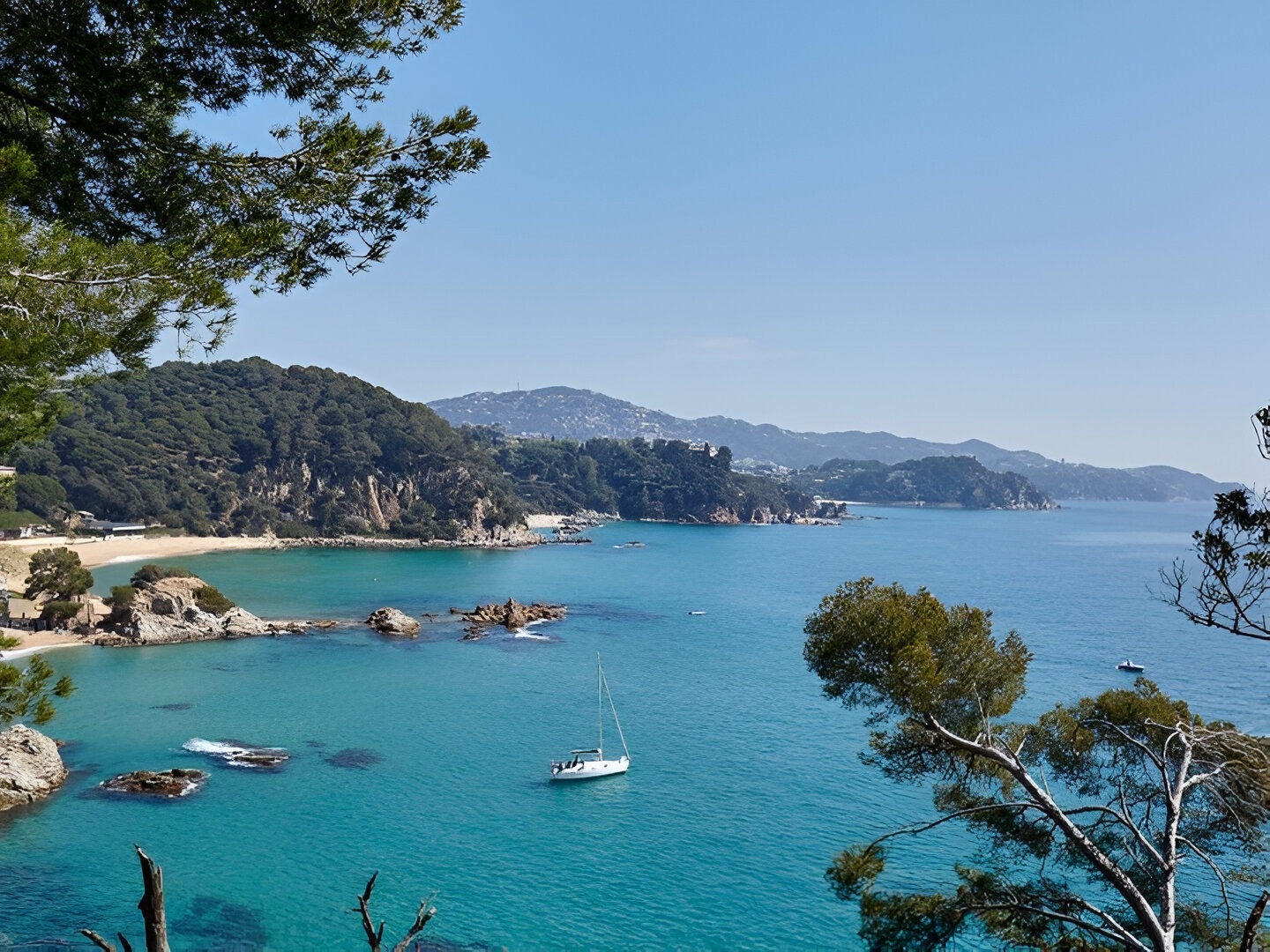 un barco blanco está anclado en el océano cerca de una playa