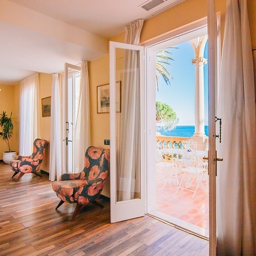 una habitación con dos sillas y una ventana con vista al océano