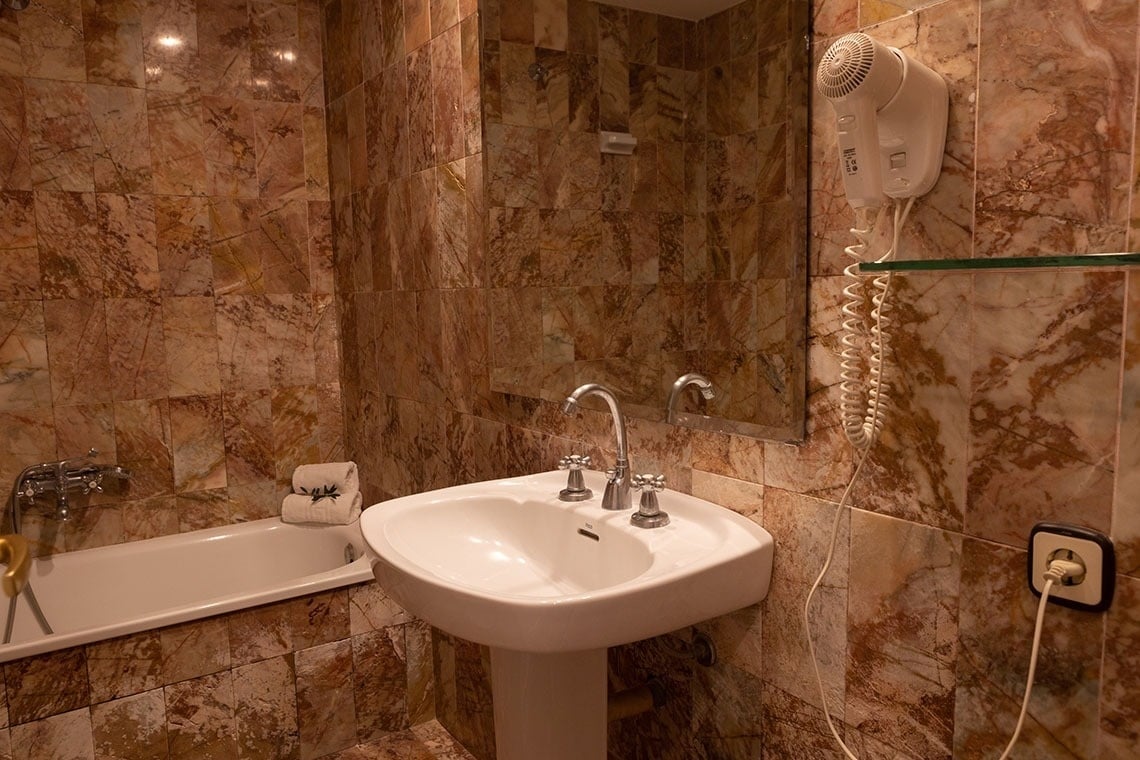 un lavabo y una bañera en un baño de mármol