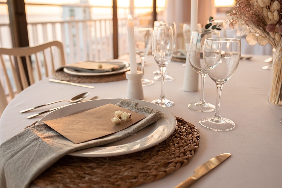 a place setting with plates glasses and candles on a table