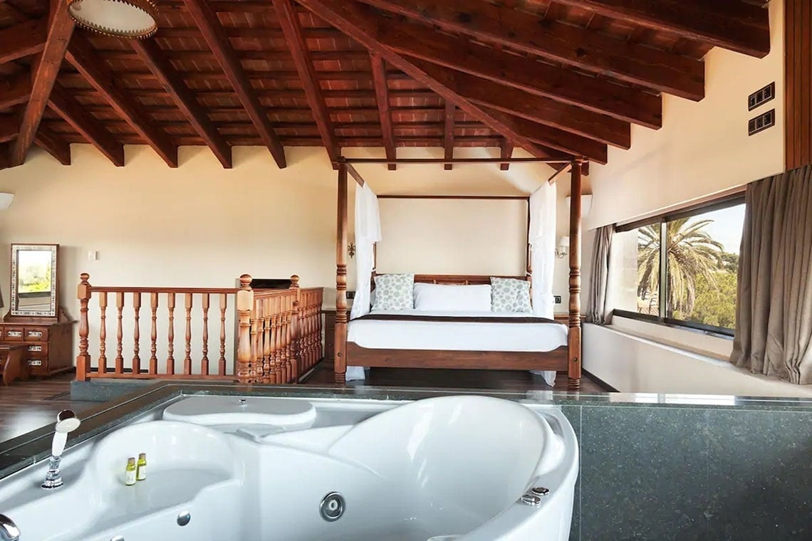 una habitación con una cama con dosel y una bañera