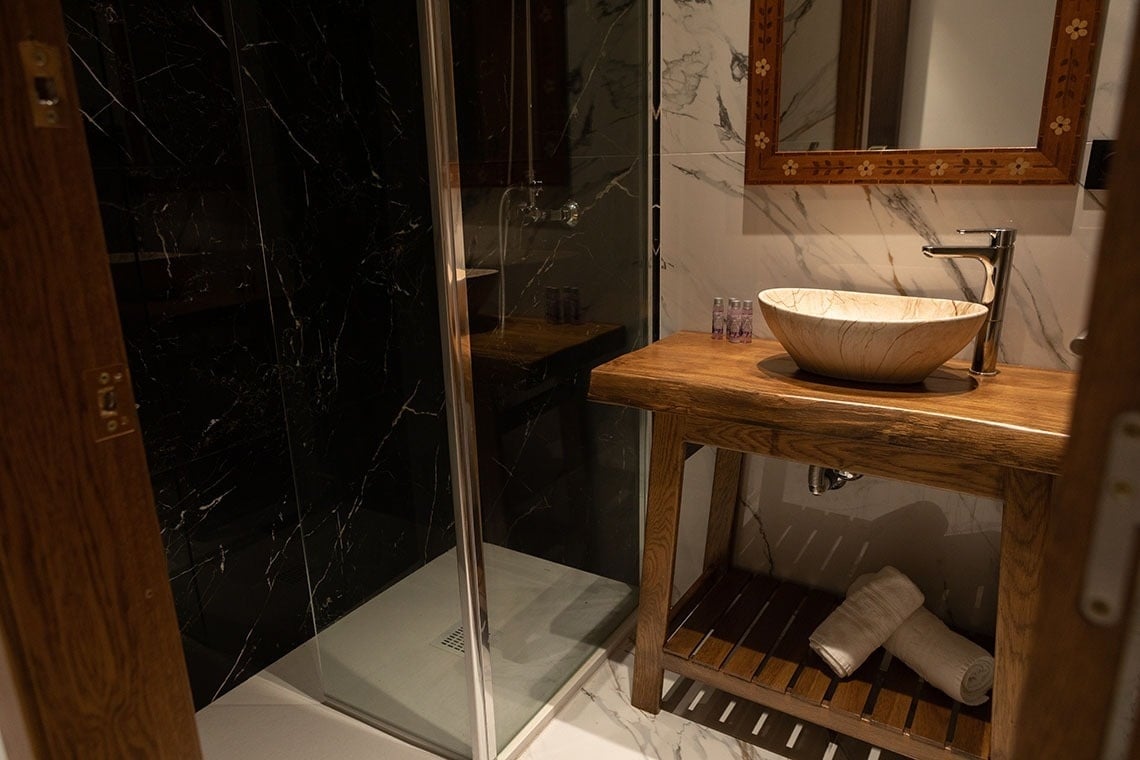 un baño con un lavabo de madera y una ducha