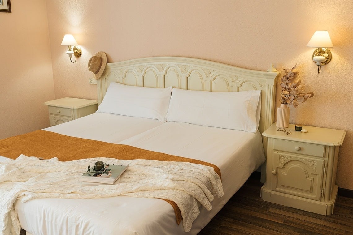 un dormitorio con una cama y dos mesitas de noche