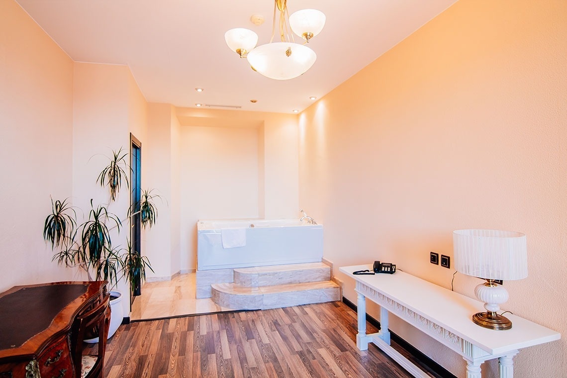 una habitación con una mesa blanca y una bañera blanca