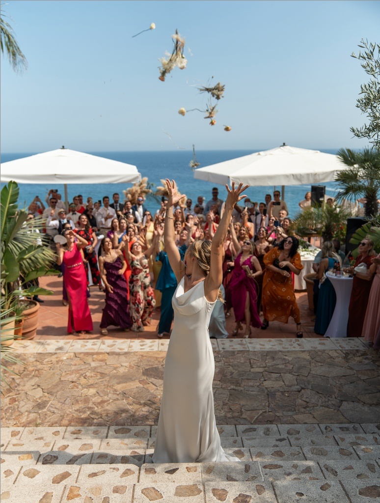 Bride throwing bouquet at Roger De Flor By Seleqtta