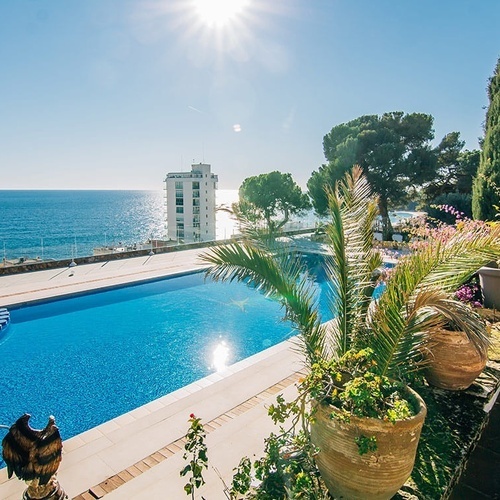 una estatua de un águila se sienta junto a una piscina con vistas al océano