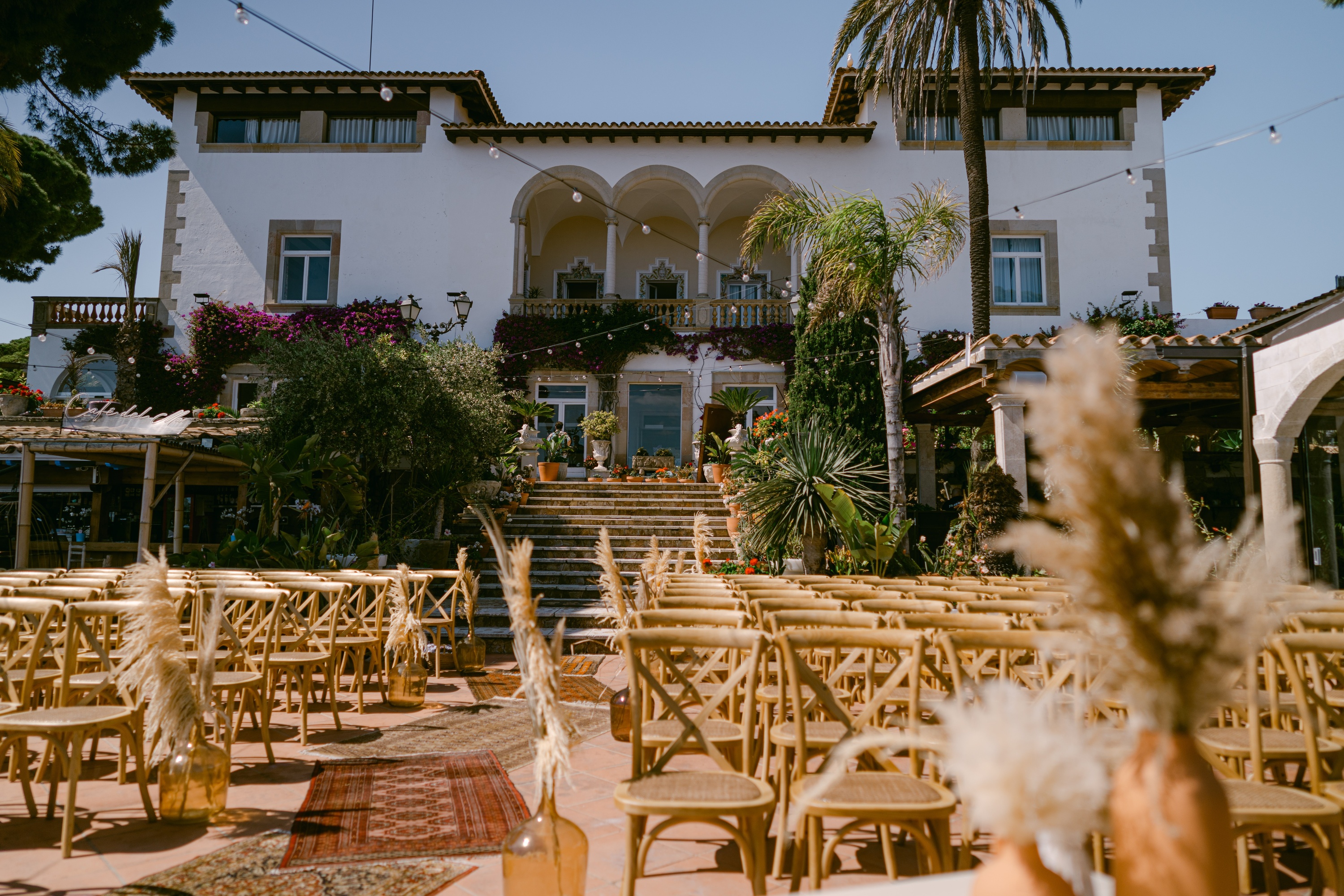 Wedding setup at Roger De Flor By Seleqtta with wooden chairs and boho decor.