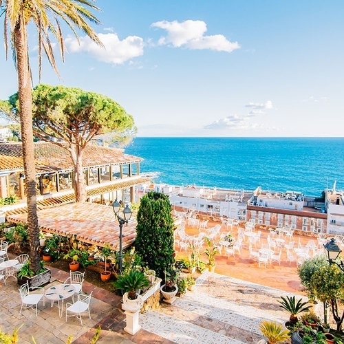 una terraza con mesas y sillas junto al océano