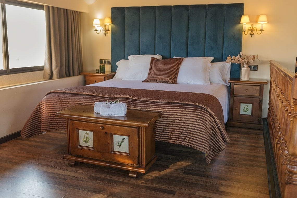 una habitación con una cama y dos mesitas de noche