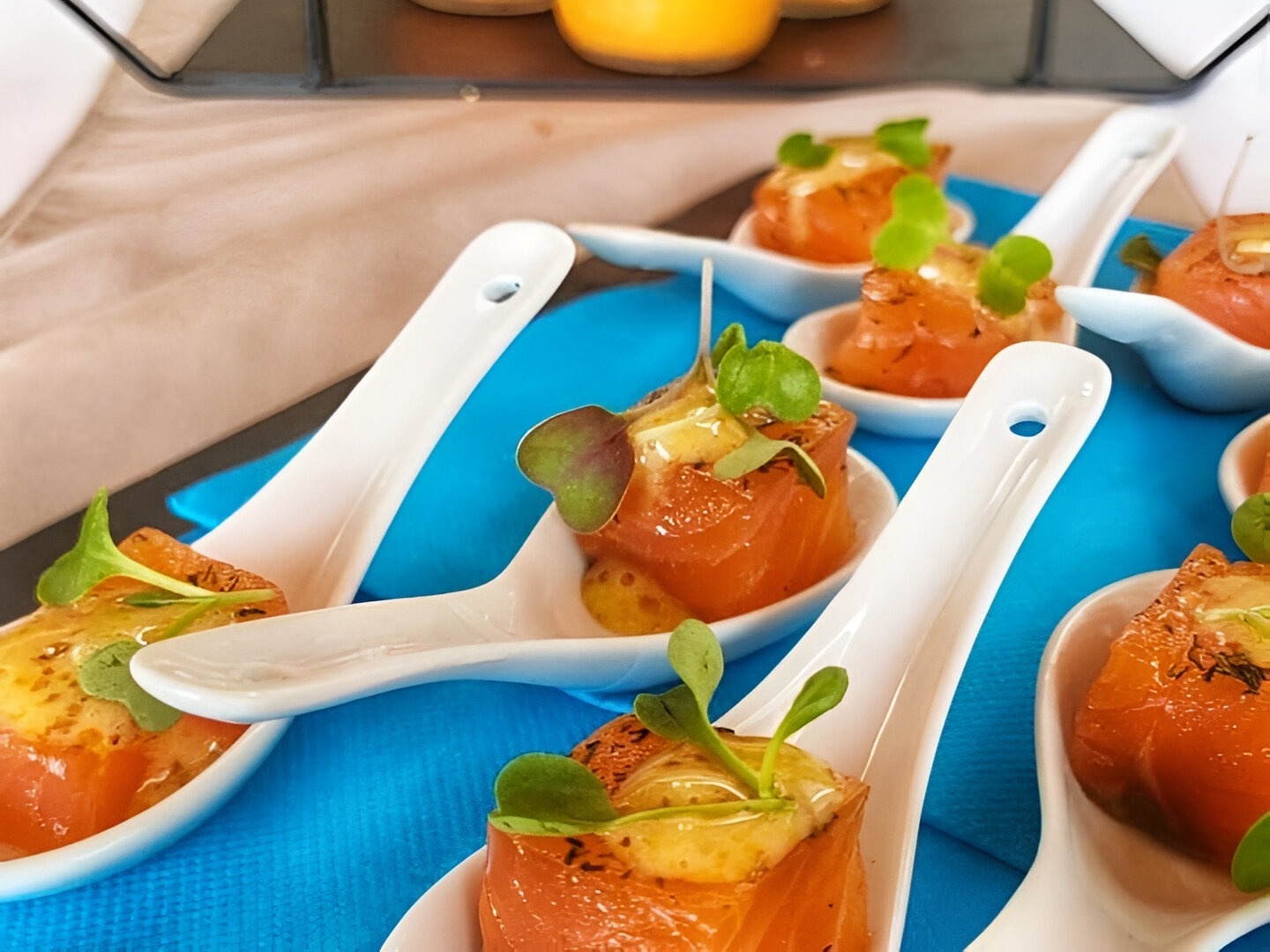 un tas de cuillères blanches remplies de nourriture sur une table bleue