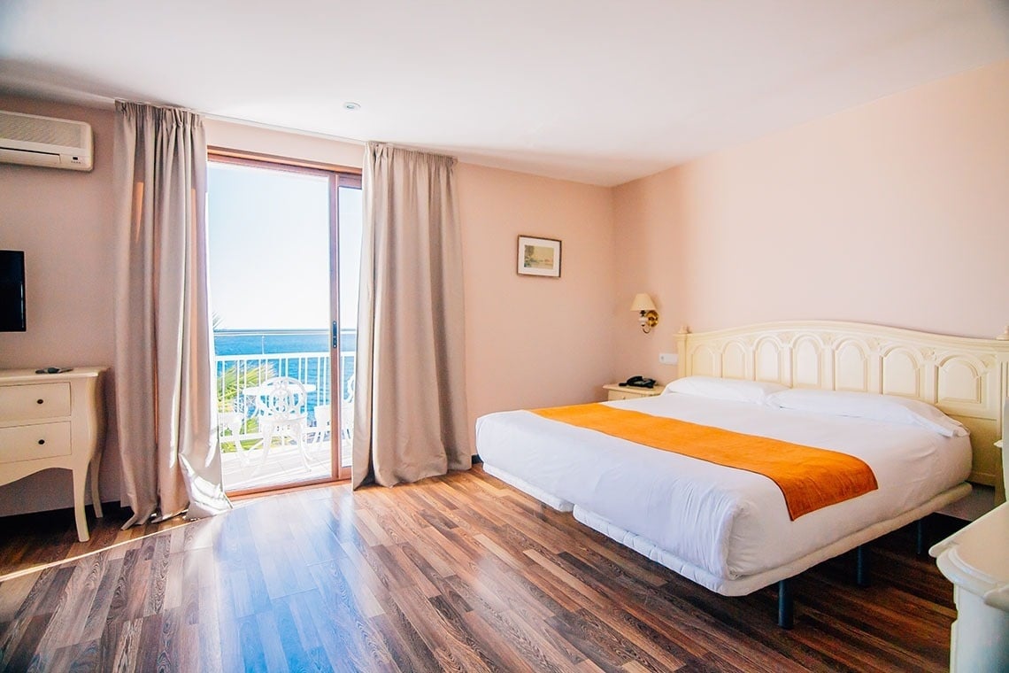 una habitación con una cama y una ventana con vista al océano