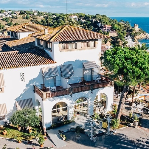 un gran edificio blanco con un techo de tejas y un balcón con vista al océano
