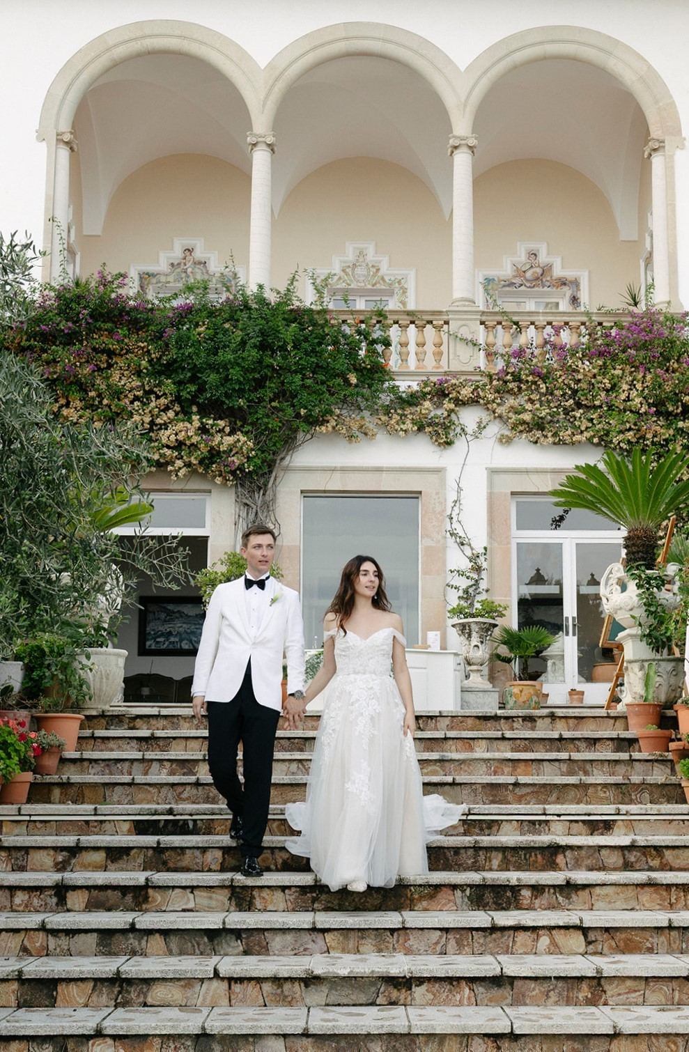 Newlyweds descend stairs at Roger De Flor By Seleqtta, Antalya.