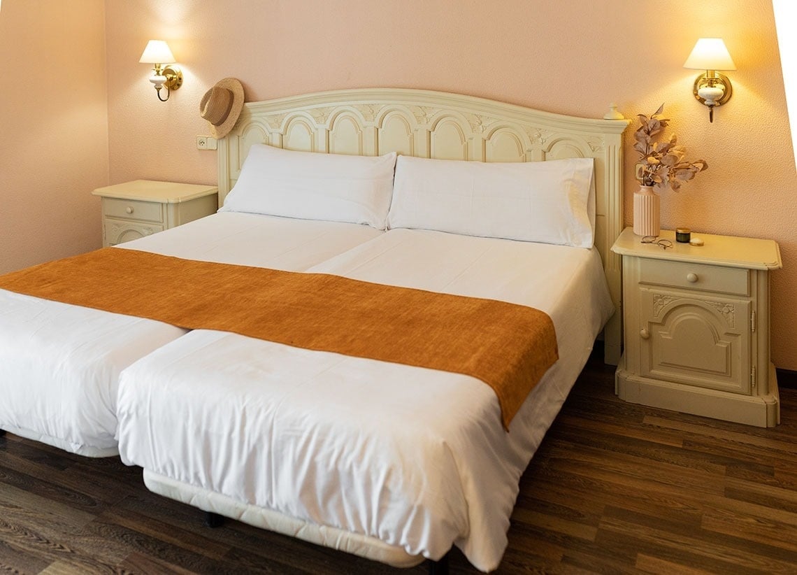 una habitación con dos camas y dos mesitas de noche