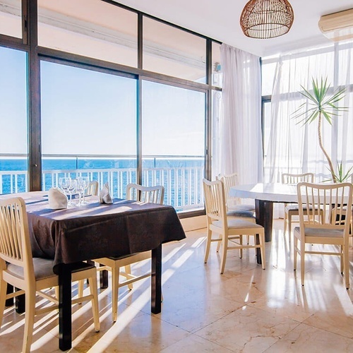 una mesa y sillas en un restaurante con vistas al océano