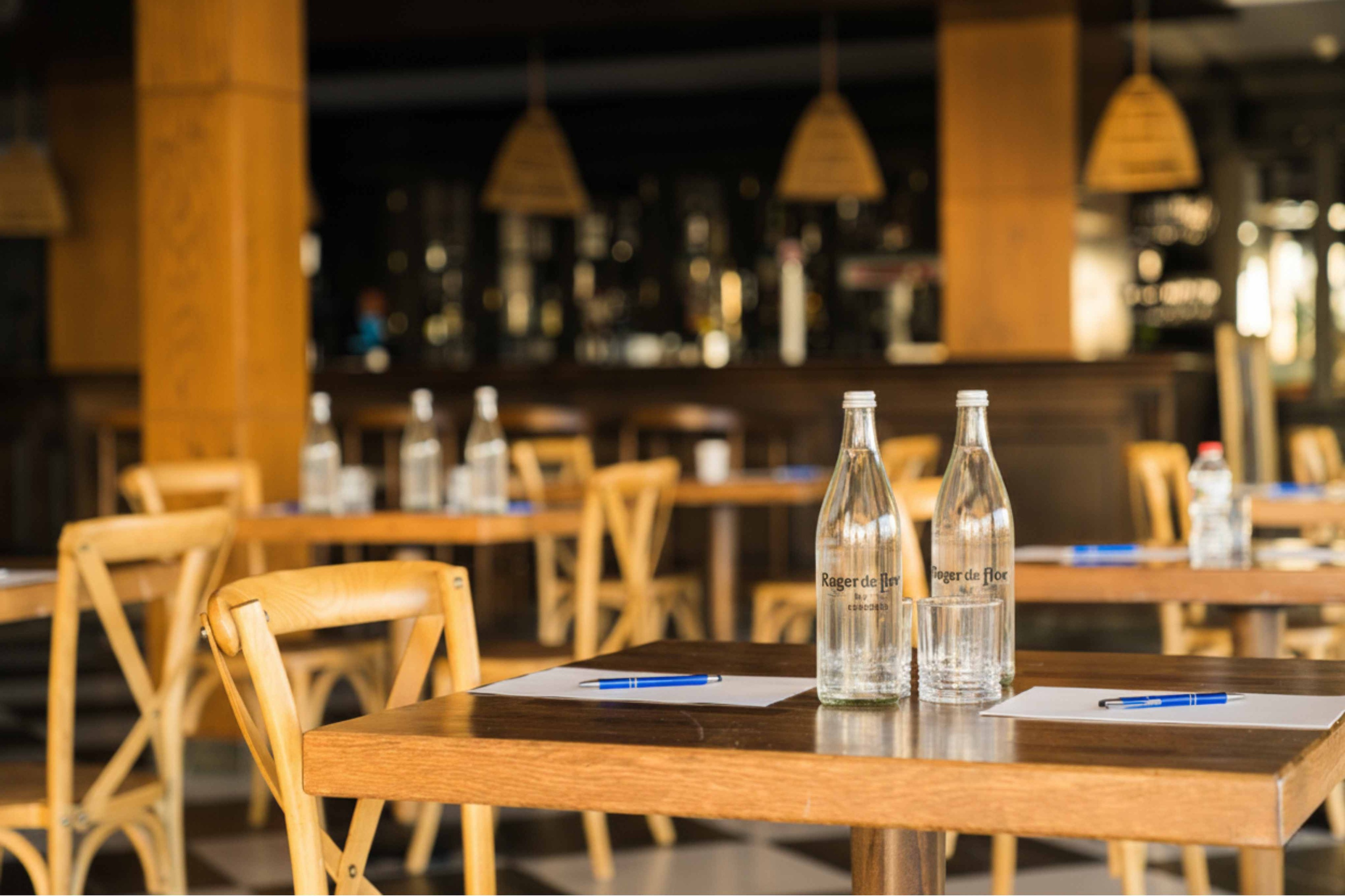Tables set at Roger De Flor By Seleqtta with water bottles.