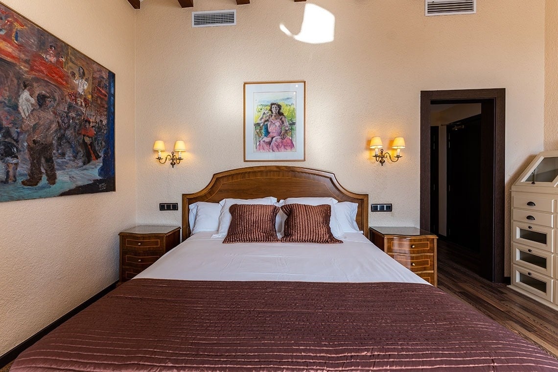 una habitación con una cama y una pintura en la pared