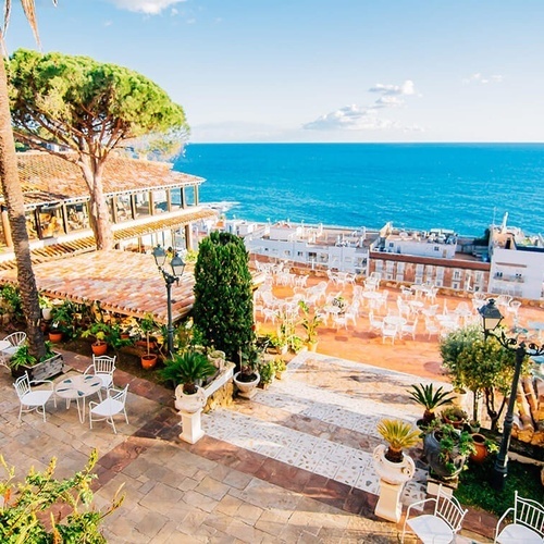 una terraza con mesas y sillas junto al océano