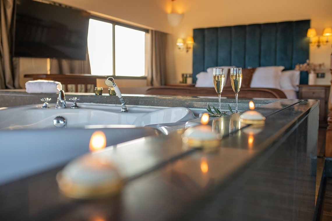 una bañera llena de velas y copas de champán